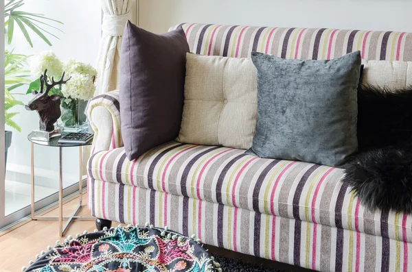Canapé coloré avec oreillers et table en verre dans le salon — Photo