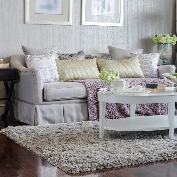 Роскошная гостиная с диваном и белым столом на ковре — стоковое фото