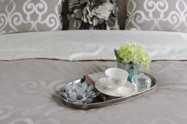 Лоток чашки чаю і ваза з квітами на ліжку — стокове фото