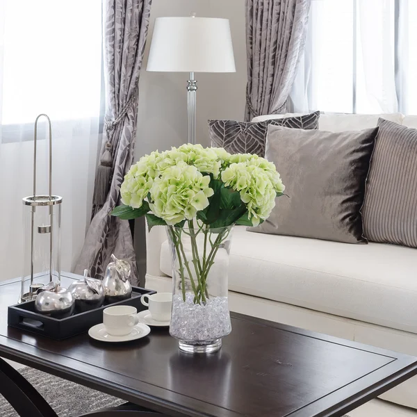 Plants in glass vase on wooden table in living room — Stock Photo, Image