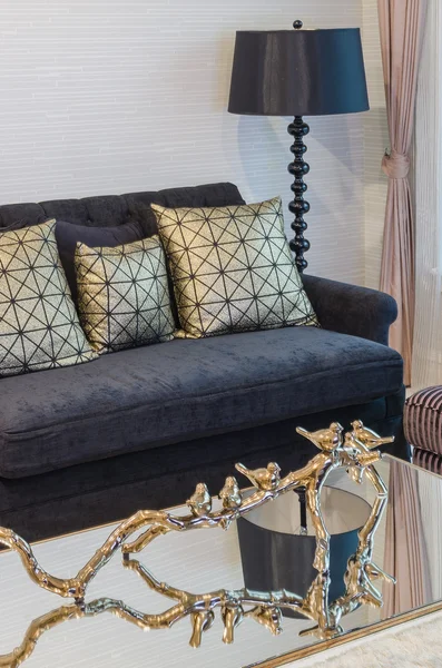 evde siyah lambalı siyah kanepe üzerinde altın yastık