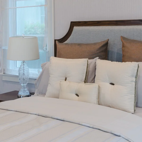 Yatak odasında lüks lambası ile beyaz yatakta beyaz yastıklar