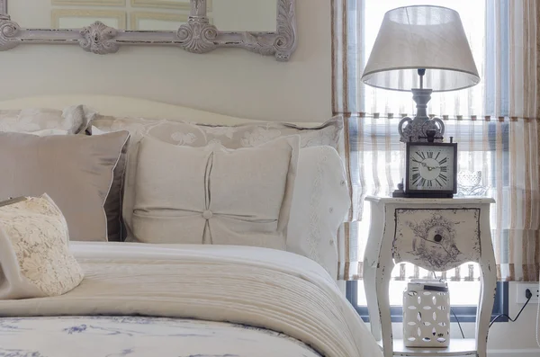 Dormitorio de lujo con lámpara y reloj en mesa blanca —  Fotos de Stock