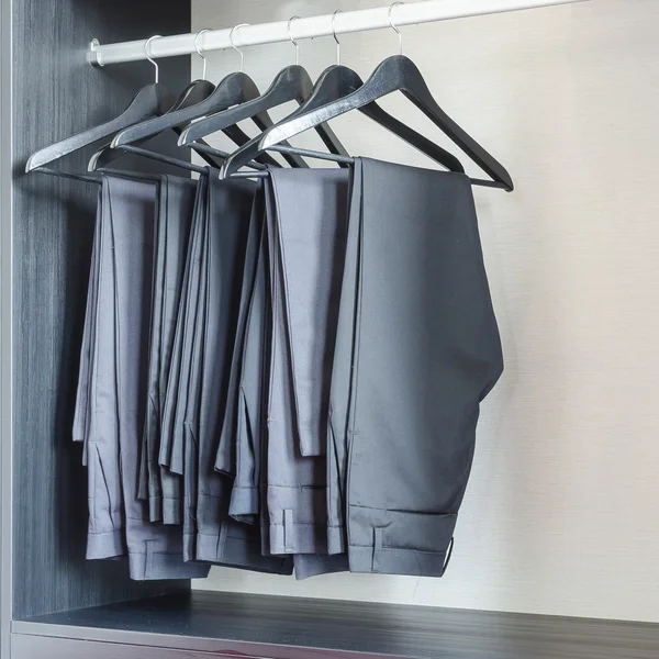 Linha de calças pretas pendura no guarda-roupa — Fotografia de Stock