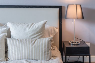 ahşap masa lüks lambası ile beyaz yatakta yastık