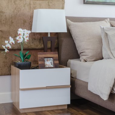 yatakta yastık yatak odasında masada beyaz lamba ile 