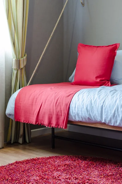 Cuscino rosso e coperta sul letto in camera da letto — Foto Stock