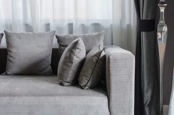 リビング ルームのモダンなソファの上の灰色の枕 — ストック写真