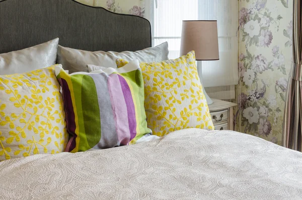 Dormitorio femenino con almohadas de colores en la cama —  Fotos de Stock