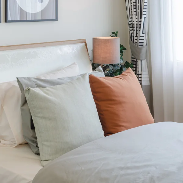 Cor laranja travesseiro na cama branca no quarto — Fotografia de Stock