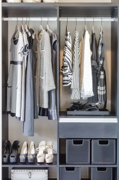 Roupas pretas e brancas no armário preto — Fotografia de Stock