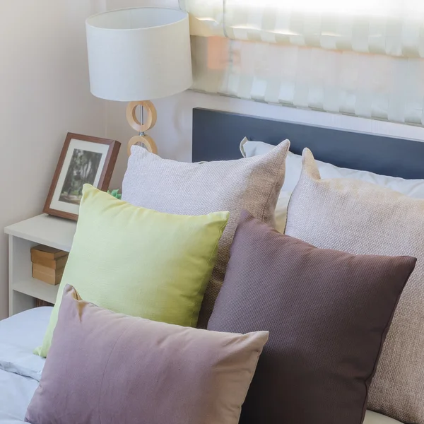 Travesseiros castanhos e travesseiros verdes na cama no quarto — Fotografia de Stock