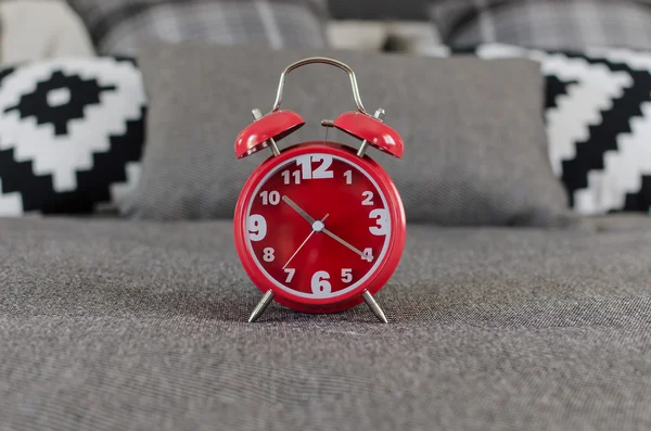 Red alarm clock on bed — Stock Photo, Image