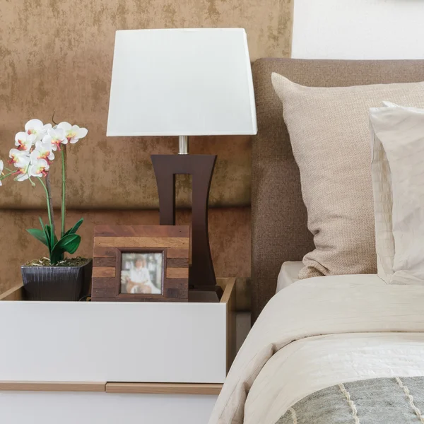 Brązowy poduszki na sofie z biała lampa na stół w sypialni — Zdjęcie stockowe