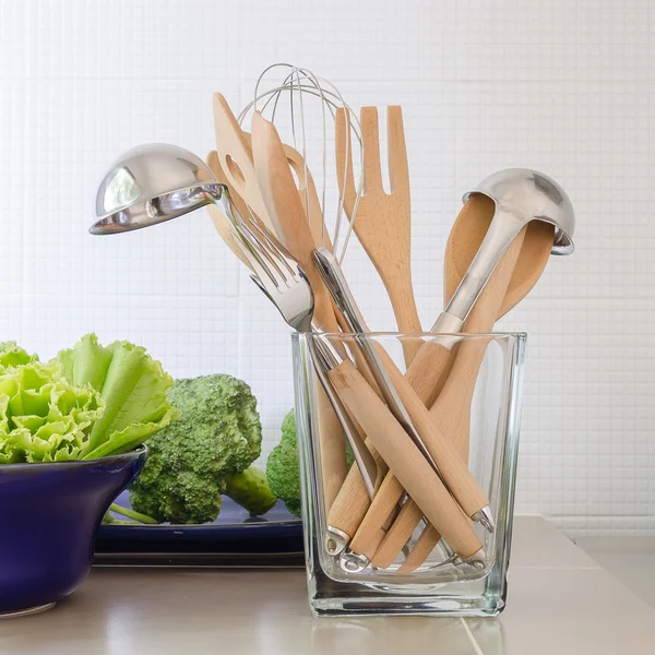 Utensils in glass bottle on kitchen's counter Stock Picture