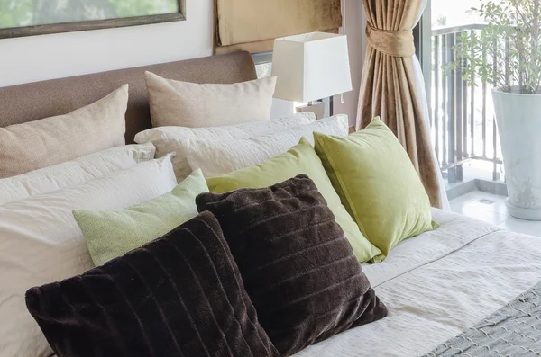 Almohadas marrones y almohadas verdes en la cama en el dormitorio — Foto de Stock