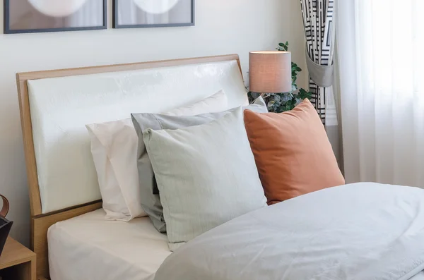 Pernă de culoare portocalie pe pat alb în dormitor — Fotografie, imagine de stoc