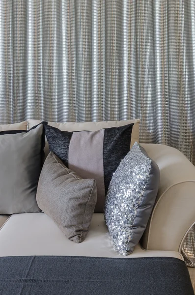 Cuscini su divano con tenda in acciaio come sfondo — Foto Stock
