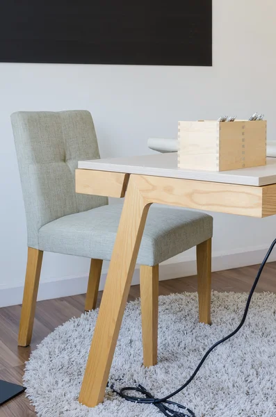 Mesa de trabalho de madeira moderna com cadeira no tapete — Fotografia de Stock