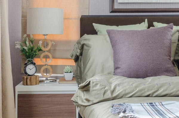 Подушки на двуспальной кровати с современной белой лампой — стоковое фото