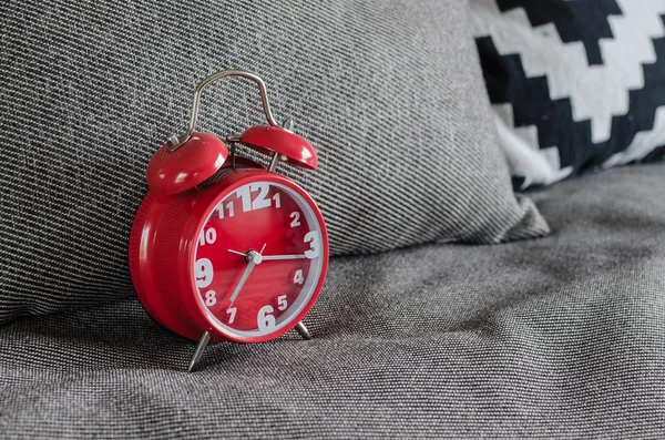 Κόκκινο ρολόι συναγερμών σε κρεβάτι — Φωτογραφία Αρχείου