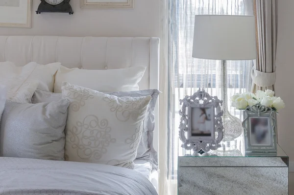 Resim çerçevesi ve cam masa lambası ile yatak odası