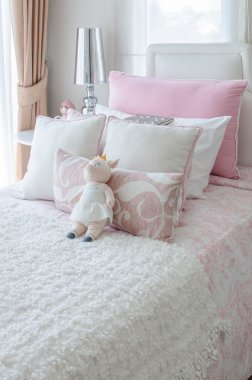 kid's bedroom with doll on bed in pink color style 