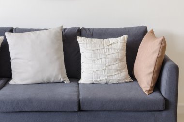 pillows on blue sofa with lamp