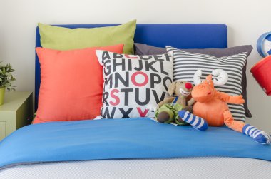 pillows on blue sofa with lamp