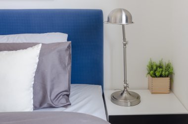 pillows on blue sofa with lamp