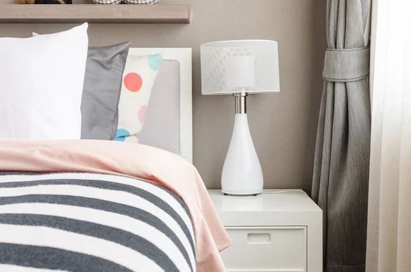 Детская спальня с белыми подушками и лампой на современной кровати — стоковое фото