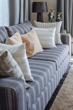 pillows on blue sofa with lamp