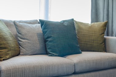 pillows on blue sofa with lamp