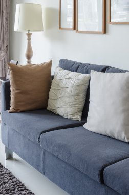 pillows on blue sofa with lamp