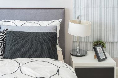 siyah ve beyaz yastık ve battaniye modern yatak var 