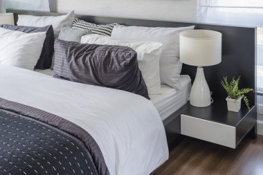 Yatak odasında siyah masada modern beyaz lamba 