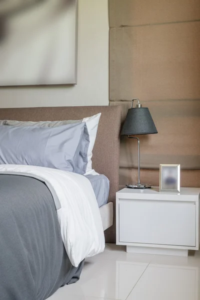 Современная спальня с черной лампой на белом столе — стоковое фото