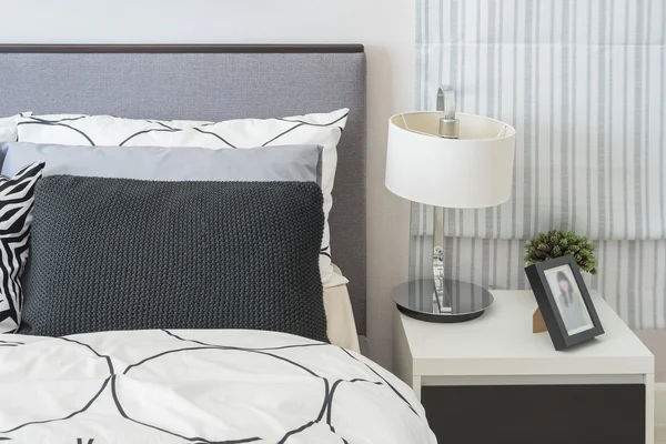 siyah ve beyaz yastık ve battaniye modern yatak var 