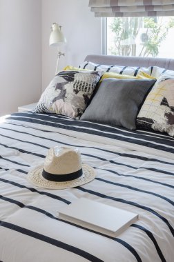 şapka ve modern yatak yastık ile üzerine beyaz kitap 