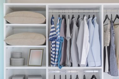 clothes hanging in white wardrobe  clipart