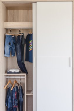 Beyaz dolapta asılı çocuk giyim 