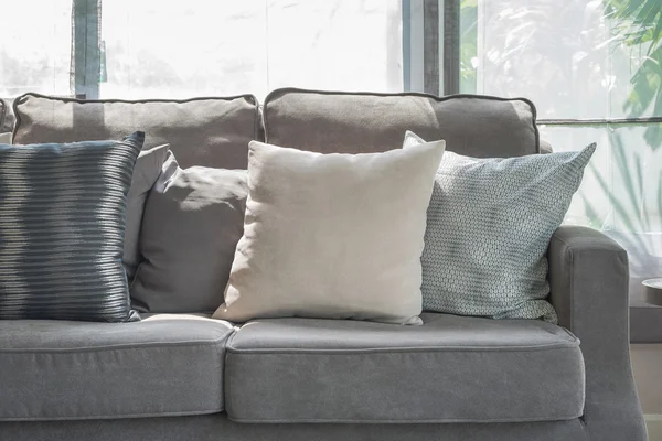 Almofadas no sofá cinza moderno na sala de estar — Fotografia de Stock