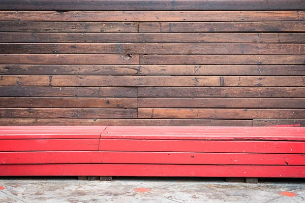 Vieux patern mural en bois avec banc en bois rouge — Photo