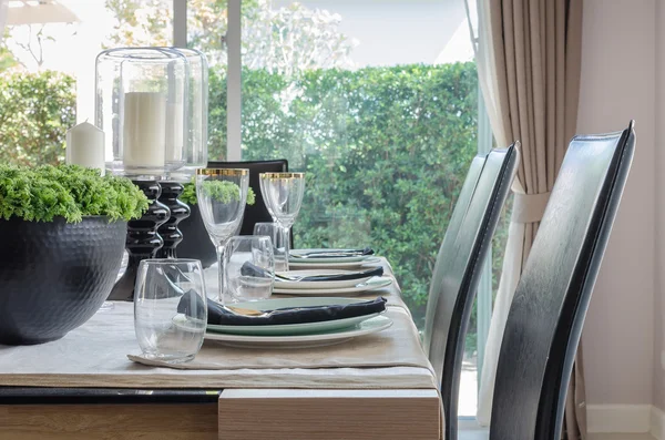 Prostřeno k večeři na jídelní stůl s černými moderní židle — Stock fotografie
