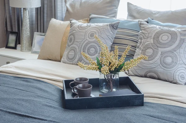 Tray of cup and glass vase of plant on bed — Stock Photo, Image