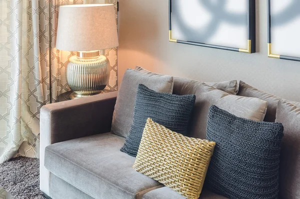 Gold and black color pillows on grey sofa — Stock Photo, Image