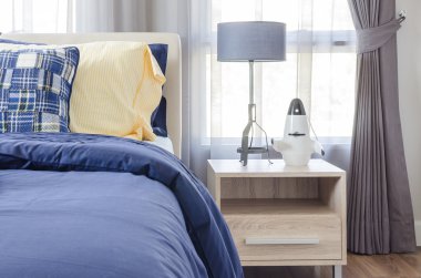 mavi ve sarı yastık ile mavi modern yatak