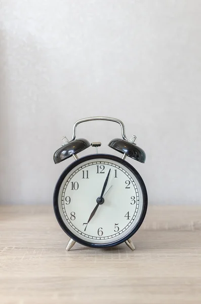 Modern black alarm clock on wooden table — Stock Photo, Image