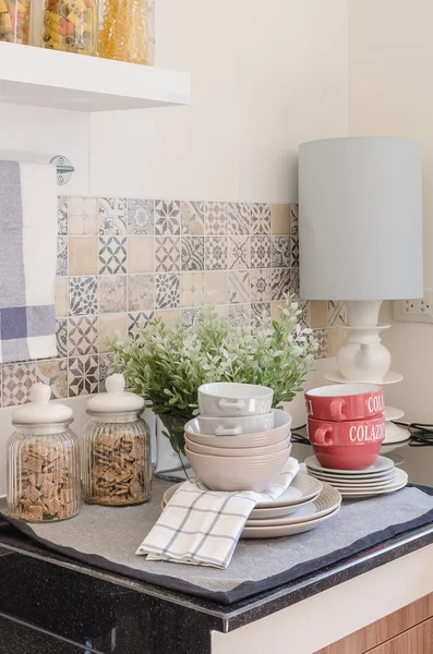 Set of plates and dish on counter in kitchen room — Stock Photo, Image