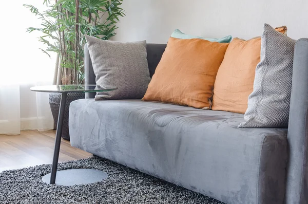 Moderno sofá gris con almohadas naranjas y mesa redonda negra —  Fotos de Stock